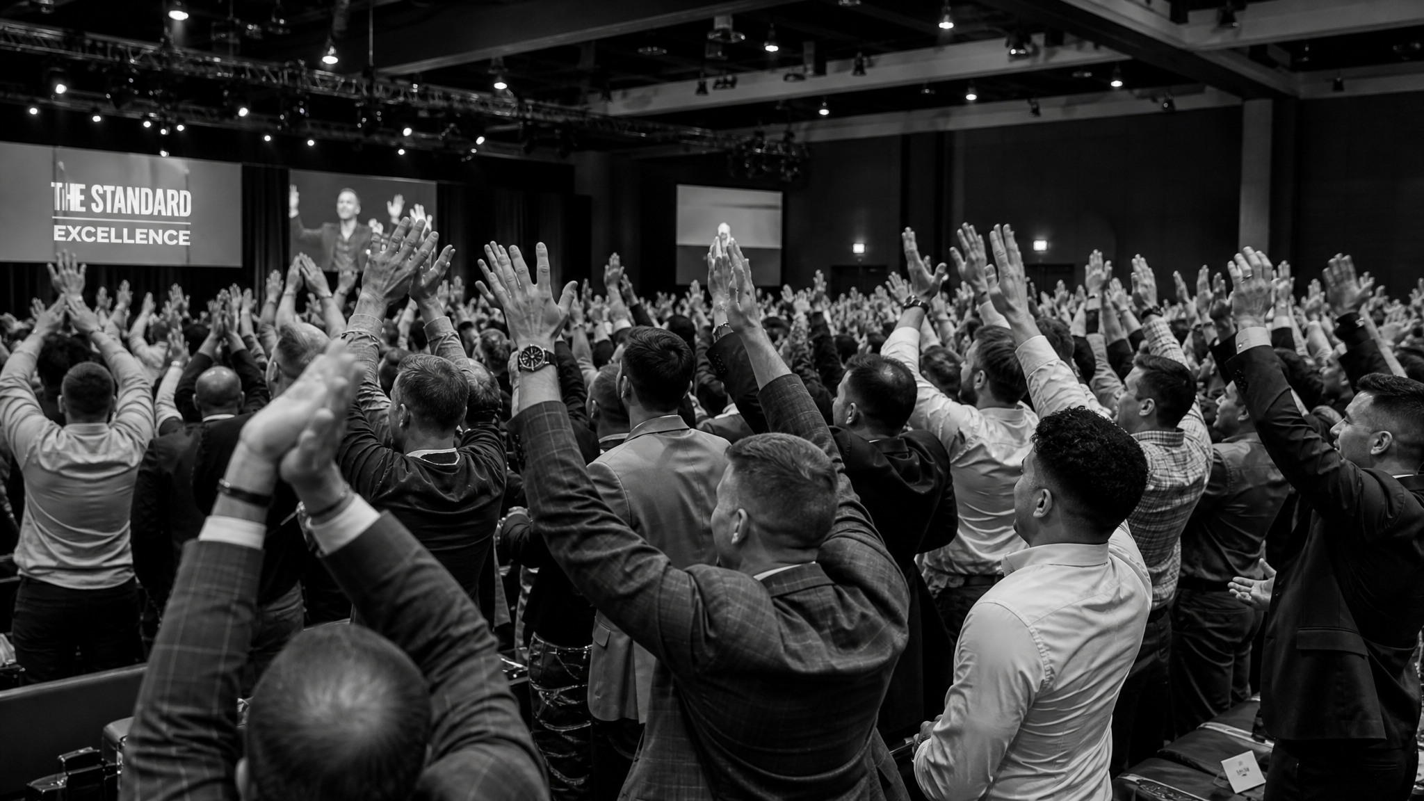 Men at a transformational event applauding